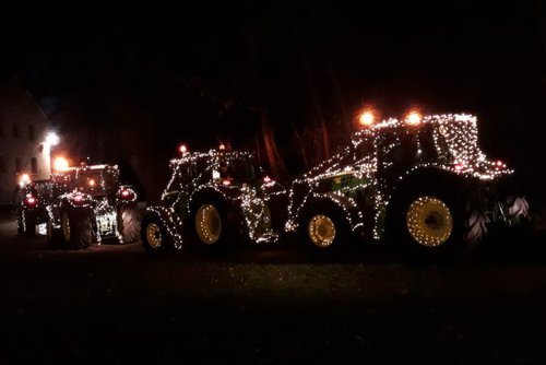 Traktoren mit Lichterketten geschmückt fahren durch die Nacht